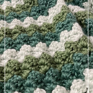 May include: Close-up of a crocheted blanket with a chevron pattern in shades of green and white. The blanket is made with a textured stitch that creates a raised, bumpy effect.