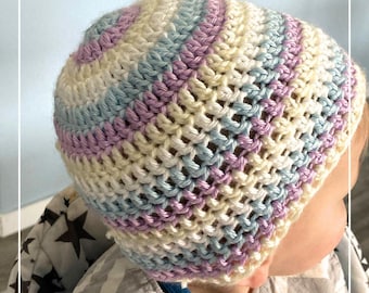 May include: A baby wearing a crocheted hat with stripes of light blue, cream, and purple. The hat is made with a simple stitch and has a loose fit. The baby is wearing a gray bib with a chevron pattern.