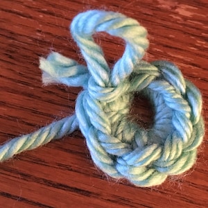 Peut inclure: Un anneau crocheté bleu clair avec une longue queue de fil.