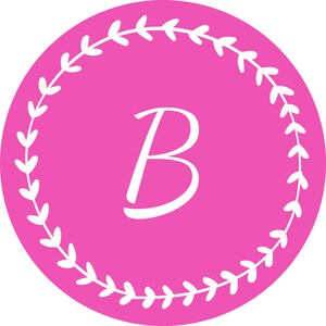 Könnte beinhalten: Ein rosa Kreis mit einem weißen Blumengirlandenrand. Der Buchstabe "B" befindet sich in der Mitte des Kreises in Weiß.