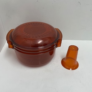 May include: A set of two amber-colored plastic containers with a lid and a separate amber-colored plastic cup.