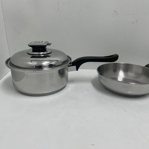 May include: A set of two stainless steel cookware pieces, a saucepan with a lid and a frying pan. Both pieces have black handles.