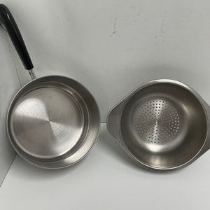 May include: Two stainless steel kitchen utensils: a saucepan with a black handle and a colander with a perforated bottom.