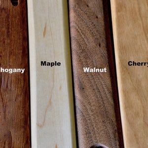 May include: Close-up of four wood samples: mahogany, maple, walnut, and cherry. Each sample is labeled with its wood type.