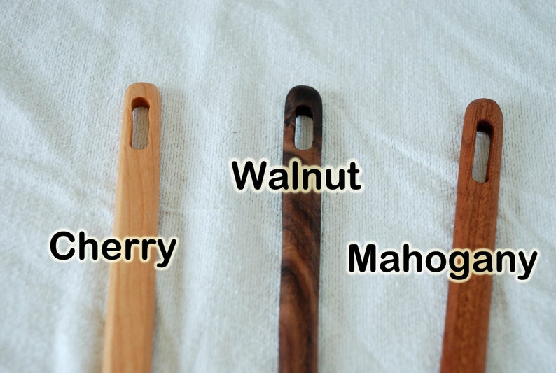 May include: Three wooden dowels with a hole in the center. The dowels are labeled "Cherry", "Walnut", and "Mahogany".