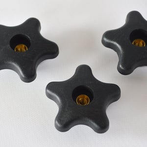 May include: Three black plastic star-shaped knobs with a threaded hole in the center.