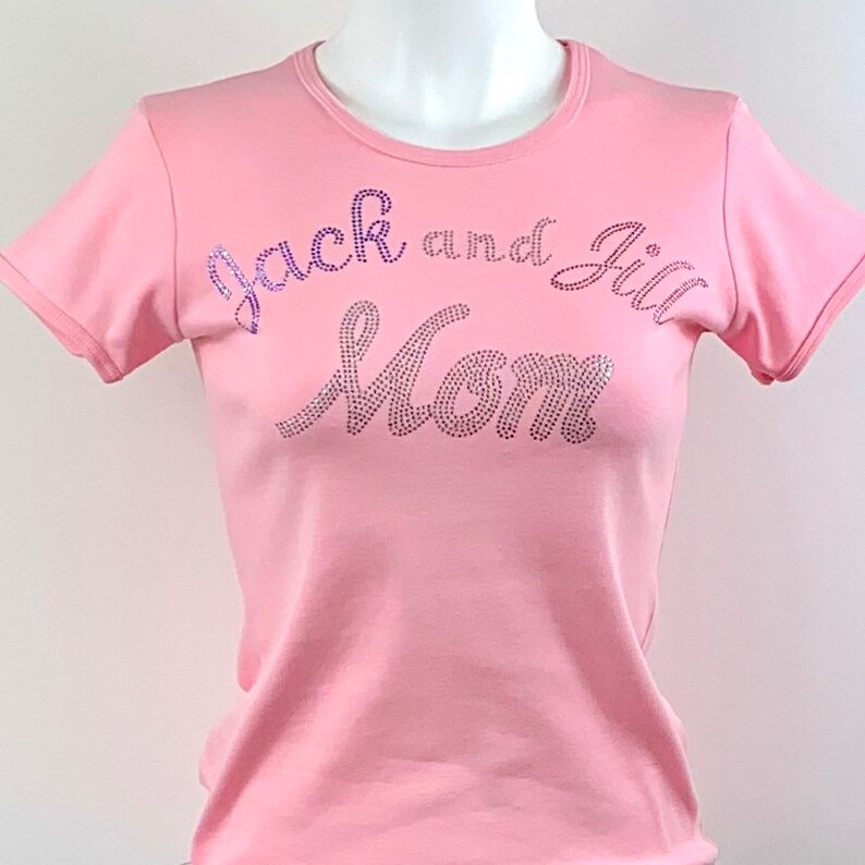 May include: Pink t-shirt with the text "Jack and Jill Mom" in purple rhinestones.