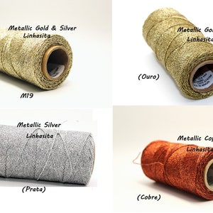 Puede incluir: Cuatro carretes de hilo Linhasita metálico en colores oro, plata y cobre. Los carretes están etiquetados con los colores y el texto "Metallic Gold & Silver", "Metallic Gold", "Metallic Silver" y "Metallic Copper".