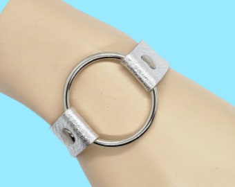 Metallic silver leather wrist cuff with silver tone O ring, rivets, & snap. Handmade. Shipping included.