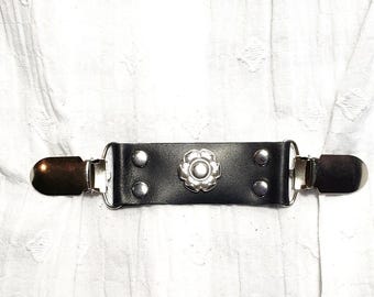 Silver tone flower center piece, black leather cinch clip. Dress clip, jacket clip, shirt clip, sweater clip, skirt clip, cloak clip.