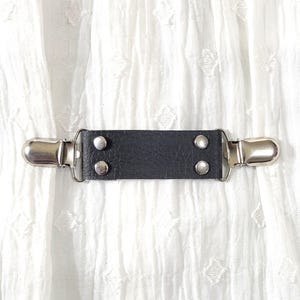 Faux black leather looking fabric cinch clip w/ silver tone clips. Shirt clip, dress clip, sweater clip, skirt clip, jacket clip, cloak clip
