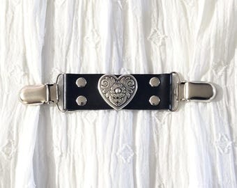 Black leather cinch clip. dress clip, jacket clip, shirt clip, sweater clip, with silver tone heart with a flower center piece, & clips.