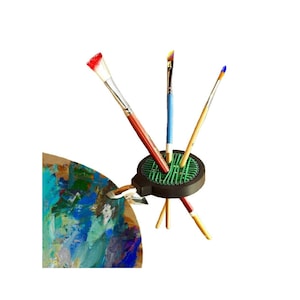 May include: A set of three ceramic mugs with a speckled, matte finish. The mugs are in shades of gray, white, and black. Each mug has a simple, modern design, suitable for coffee or tea. The mugs are stacked on top of each other.