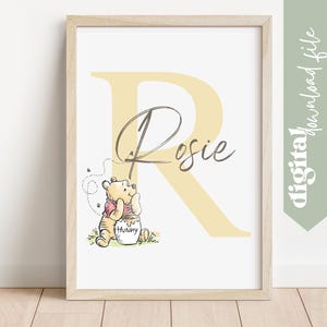 May include: A framed print featuring a yellow letter "R" with the name "Rosie" in script. A Winnie the Pooh illustration sits below the name, with a honey pot. The words "digital download file" are on the right side.