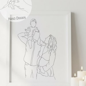 May include: A framed line art print showing a family of three. The artwork depicts a father with a child on his shoulders, and a pregnant mother looking up. The print is labelled "HAND DRAWN".