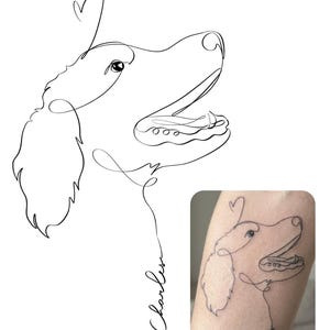 Puede incluir: Un dibujo de una sola línea en blanco y negro de un perro de perfil con la boca abierta y una forma de corazón sobre la cabeza. El nombre Charles está escrito en cursiva debajo del perro. Una versión más pequeña aparece como tatuaje.
