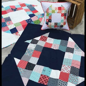 May include: A blue, red, and white patchwork quilt with a churn dash pattern. The quilt is made from charm squares and is available in three sizes: 60 inches by 60 inches, 48 inches by 48 inches, and 20 inches by 20 inches.