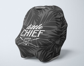 Op de afbeelding: Een grijze autostoelhoes met een tropisch bladmotief en de tekst "little CHIEF" in wit.