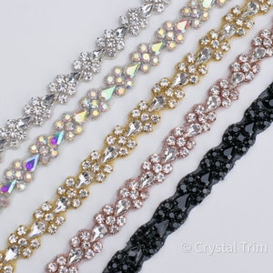 May include: Five rows of crystal trim ribbon, each with a different color and style of rhinestones. The top row is silver, the second row is iridescent, the third row is gold, the fourth row is rose gold, and the bottom row is black.