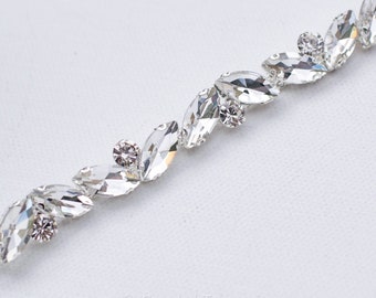 May include: A silver trim with clear crystal rhinestones in a marquise shape. The rhinestones are arranged in a staggered pattern.