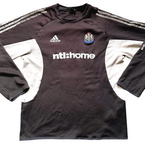 May include: Black and white long-sleeved football shirt with the Adidas logo, a team crest, and the text "ntl:home".