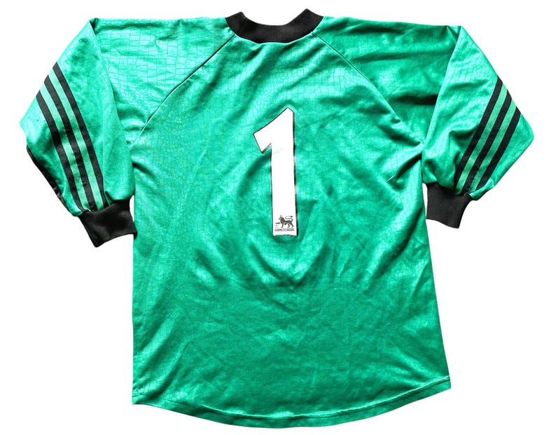 K&ouml;nnte beinhalten: Lang&auml;rmeliges, smaragdgr&uuml;nes Fu&szlig;balltrikot mit schwarzen Akzenten. Auf der R&uuml;ckseite ist die wei&szlig;e Nummer 1 zu sehen. Das Trikot hat schwarze Streifen auf den &Auml;rmeln, einen schwarzen Kragen und B&uuml;ndchen und ein strukturiertes Muster.