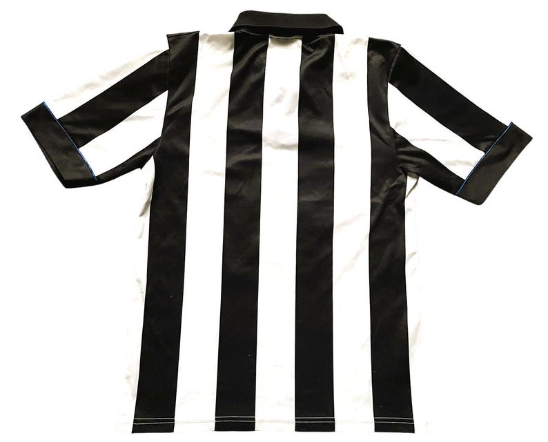 May include: A black and white striped collared shirt. The shirt has short sleeves with a blue trim on the cuffs. The shirt has a black collar and a white and black striped pattern.