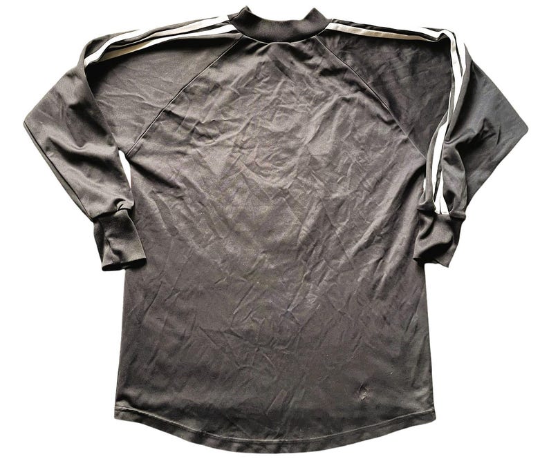 May include: A dark gray long-sleeved athletic shirt with a mock neck and white stripes down the sleeves and across the shoulders. The shirt has a small logo on the lower front.