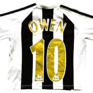 May include: White and black striped soccer jersey with the name "OWEN" and the number "10" in gold. The jersey has black stripes on the shoulders and the Premier League logo.