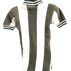Puede incluir: Una camisa de manga corta a rayas blancas y negras con un cuello a rayas blancas y negras.