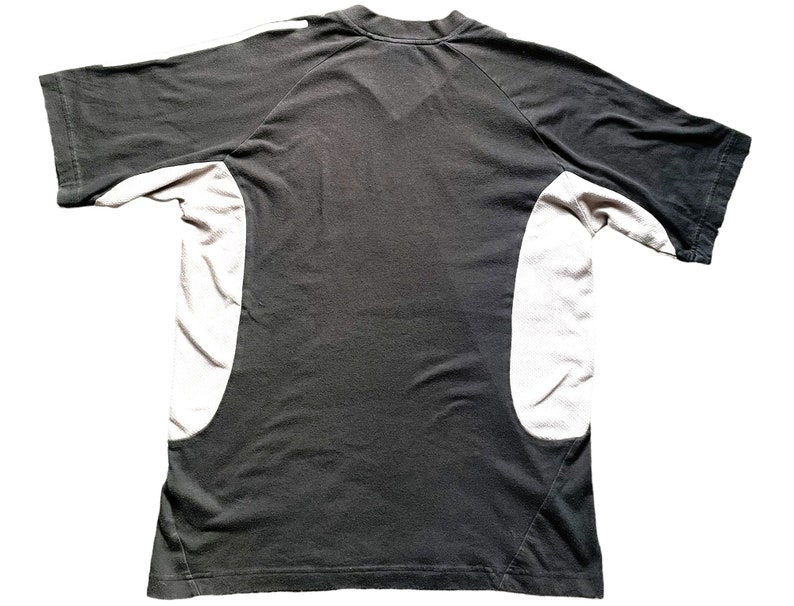 May include: Black short-sleeved t-shirt with white panels on the sides. The shirt has a crew neck and a relaxed fit.