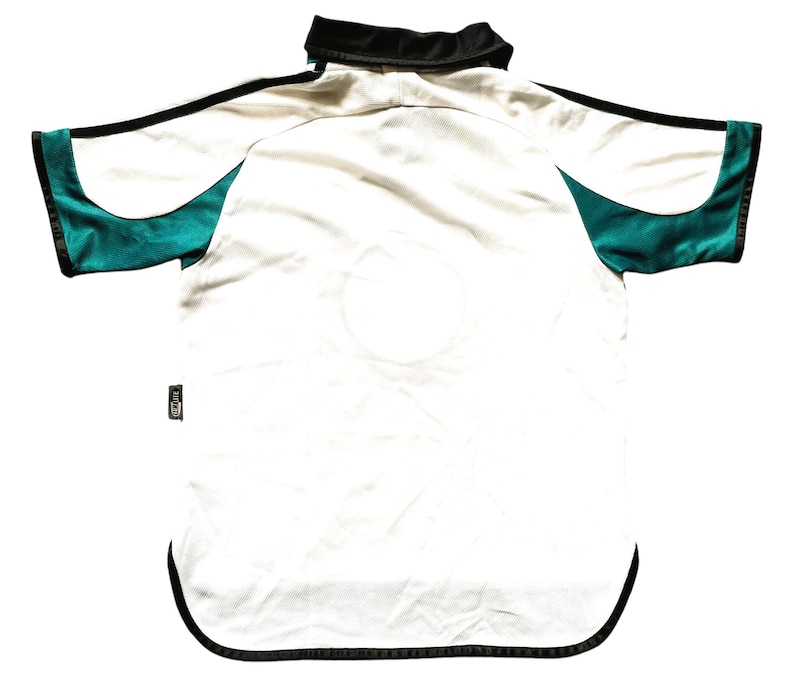 May include: White short-sleeved jersey with black trim and green accents on the sleeves.