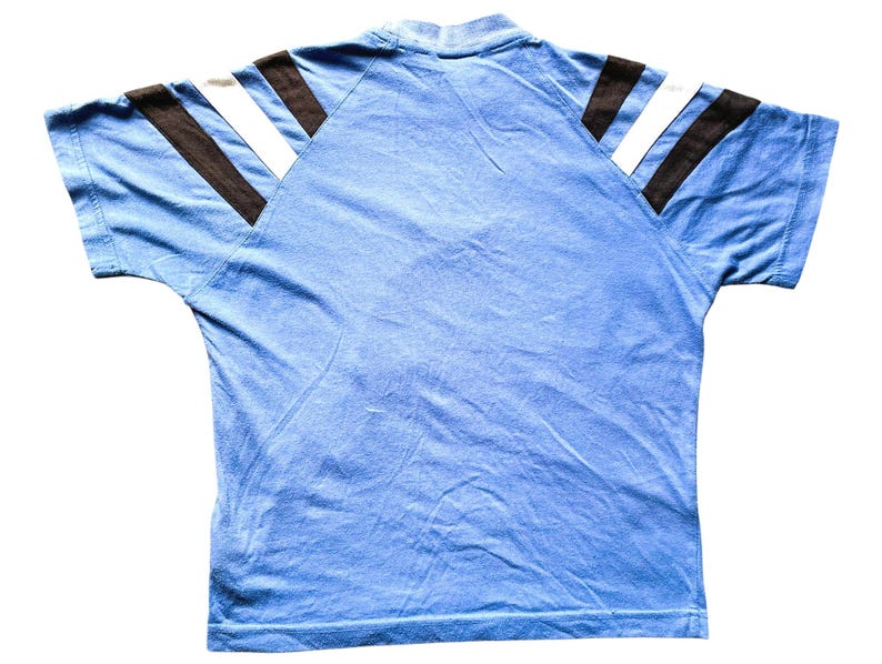 May include: A light blue short-sleeved t-shirt with black and white stripes on the shoulders.