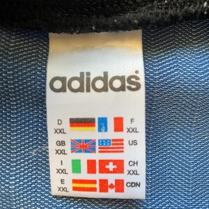 May include: White tag with black text "adidas" and size chart in multiple languages. The tag shows sizes for Germany, Great Britain, Italy, Spain, Switzerland, the United States, and Canada.