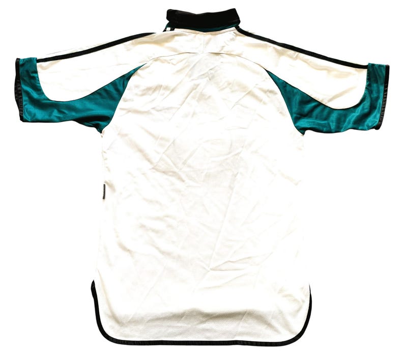 May include: White and teal athletic jersey with black trim. The jersey has a collared neckline and a curved hemline. Teal panels are on the sleeves and sides. The jersey is made of a lightweight, possibly satin-like material.