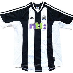 May include: Black and white striped soccer jersey with the Adidas logo, a Newcastle United crest, and the word "ntl:" in green and purple letters.