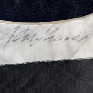 Puede incluir: Una camisa a rayas blancas y negras con una firma manuscrita que dice "Alvy Singer" en la secci&oacute;n blanca de la camisa.