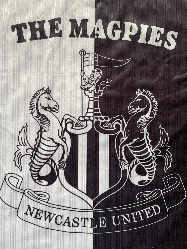 May include: A black and white striped fabric featuring the words "THE MAGPIES". The Newcastle United crest is displayed, with two seahorses, a flag, and the words "NEWCASTLE UNITED" on a ribbon.