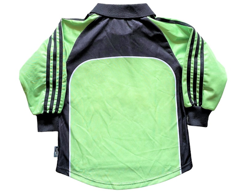 May include: A long-sleeved soccer jersey with black and white stripes on the sleeves. The jersey is green with a black collar and a white trim around the collar. The jersey has a white logo on the front.