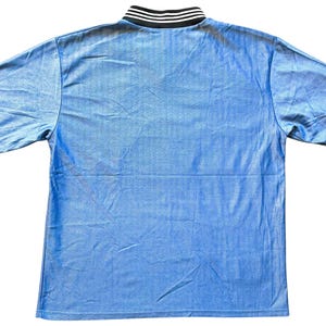 May include: A light blue short-sleeved shirt with a black and white striped collar.