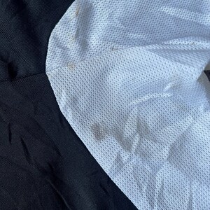 May include: Close-up of a black and white fabric with a mesh texture. The white fabric has a slightly textured surface.