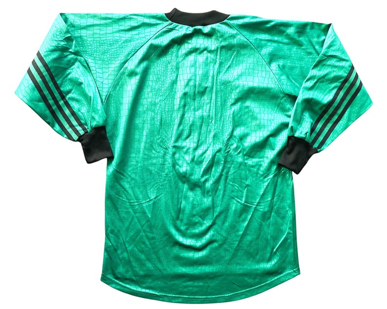May include: A long-sleeved, emerald green athletic jersey with a textured pattern. The jersey features black stripes on the sleeves and black cuffs and collar. The jersey is made of a shiny material.