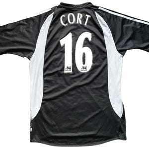 May include: Black soccer jersey with white accents and the name "Cort" and number "16" on the back.
