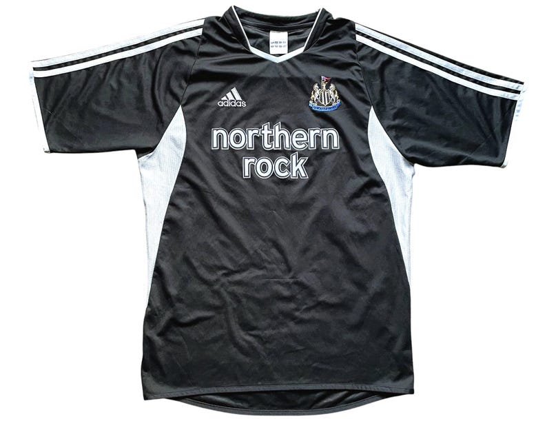 May include: Black and white soccer jersey with the Adidas logo, a team crest, and the text "northern rock" on the front.