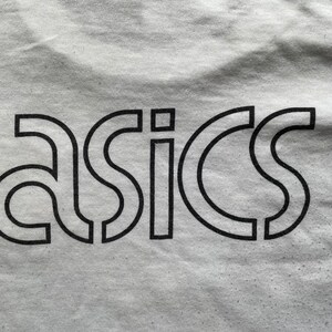 May include: A white t-shirt with a black "ASICS" logo printed on the front.