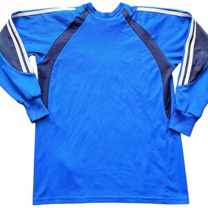 May include: A blue long-sleeved shirt with black and white stripes on the sleeves.