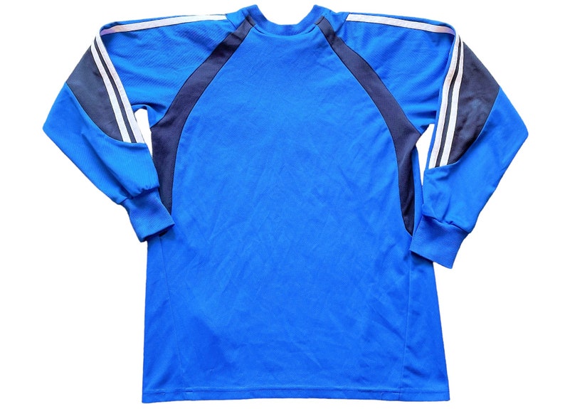 May include: A blue long-sleeved shirt with black and white stripes on the sleeves.