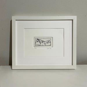Peut inclure: Une estampe encadrée en noir et blanc d'un dessin au trait simple d'une maison avec deux fenêtres. L'estampe est intitulée "025" et datée de "Oct '22".