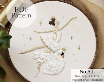 May include: Embroidered hoop art featuring a ballerina atop a swan, both adorned with gold crowns. The design is stitched in white and gold thread on a cream-colored fabric. The text "PDF Pattern" and "No A.I. This Shop Is AI Free! Support True Handmade" are also visible.