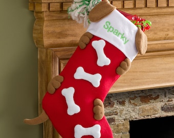 May include: A red Christmas stocking shaped like a dog, with white bone accents and brown paws and ears. The stocking has the name "Sparky" embroidered in green on the white cuff. A dog tail extends from the bottom.